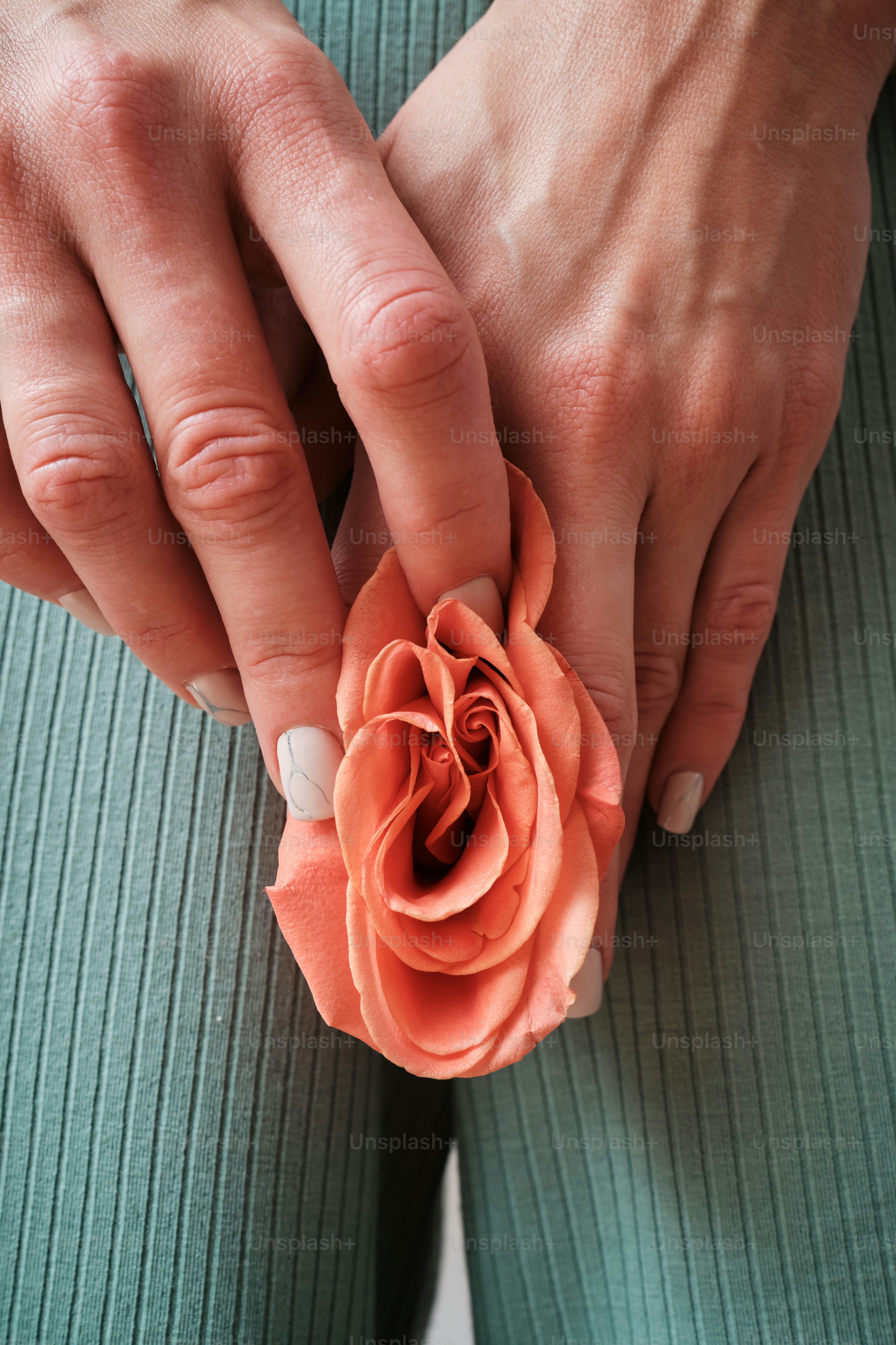 una mujer sosteniendo una flor en sus manos