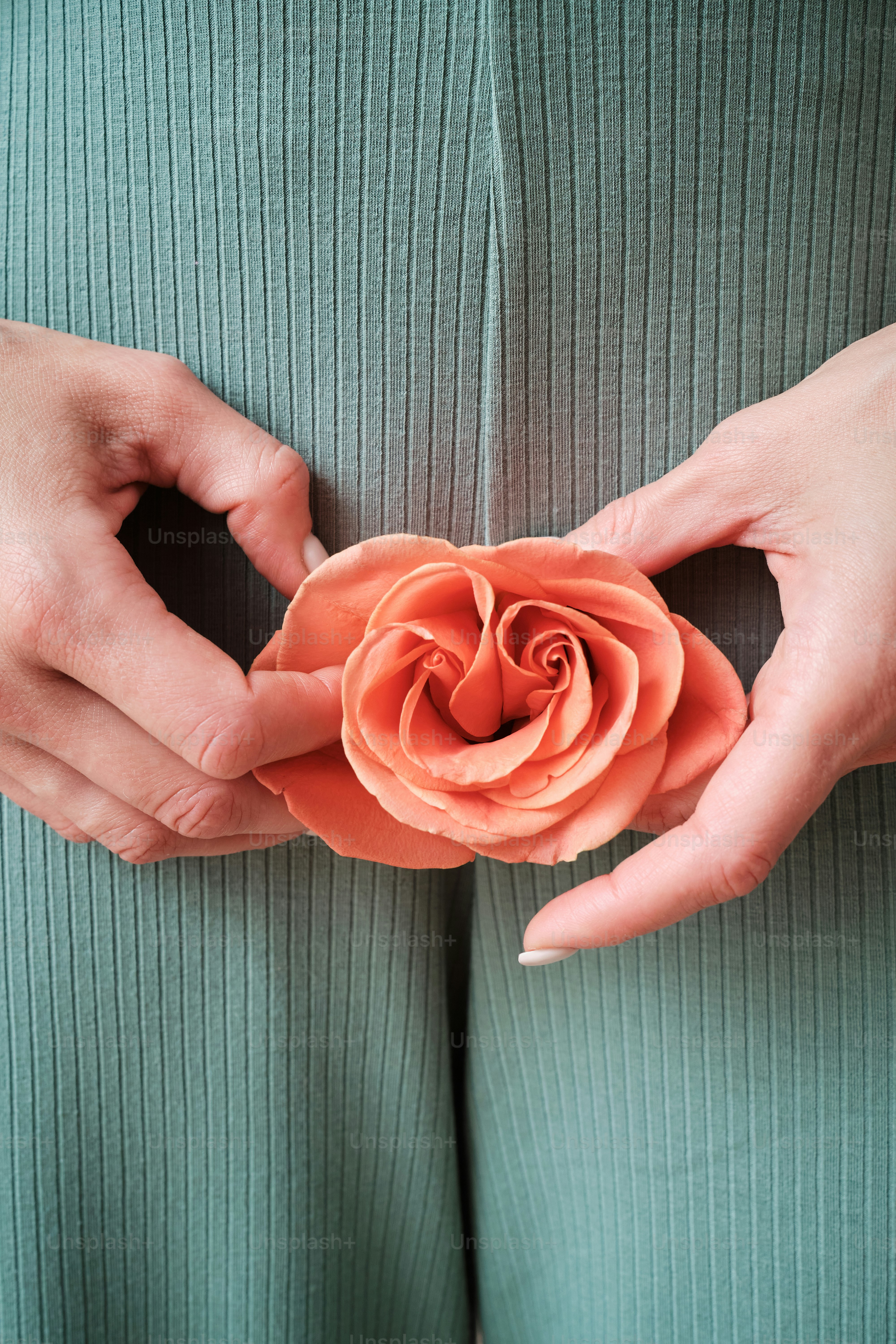 una mujer sosteniendo una flor en sus manos