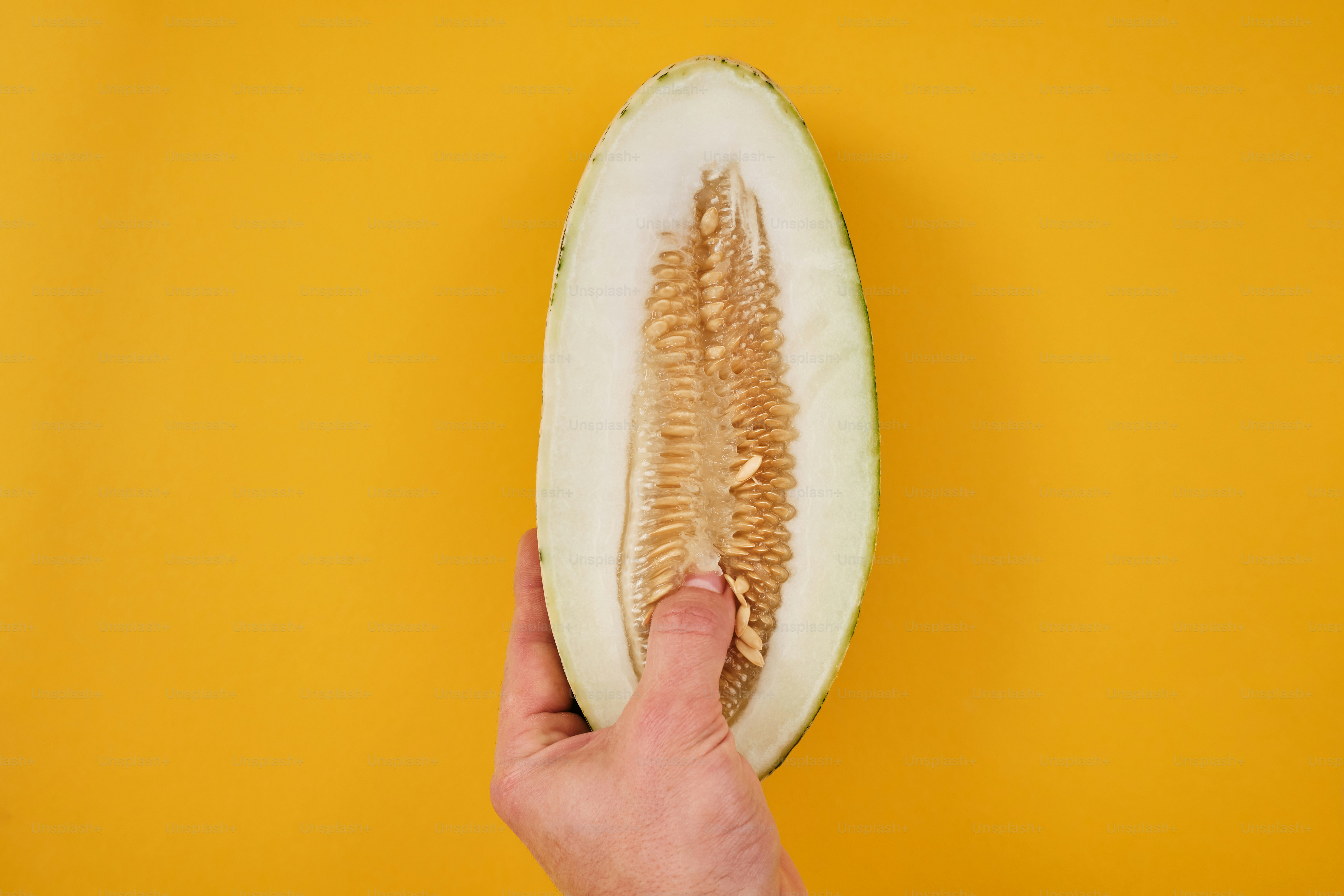 Eine Person hält eine halbe Melone in der Hand