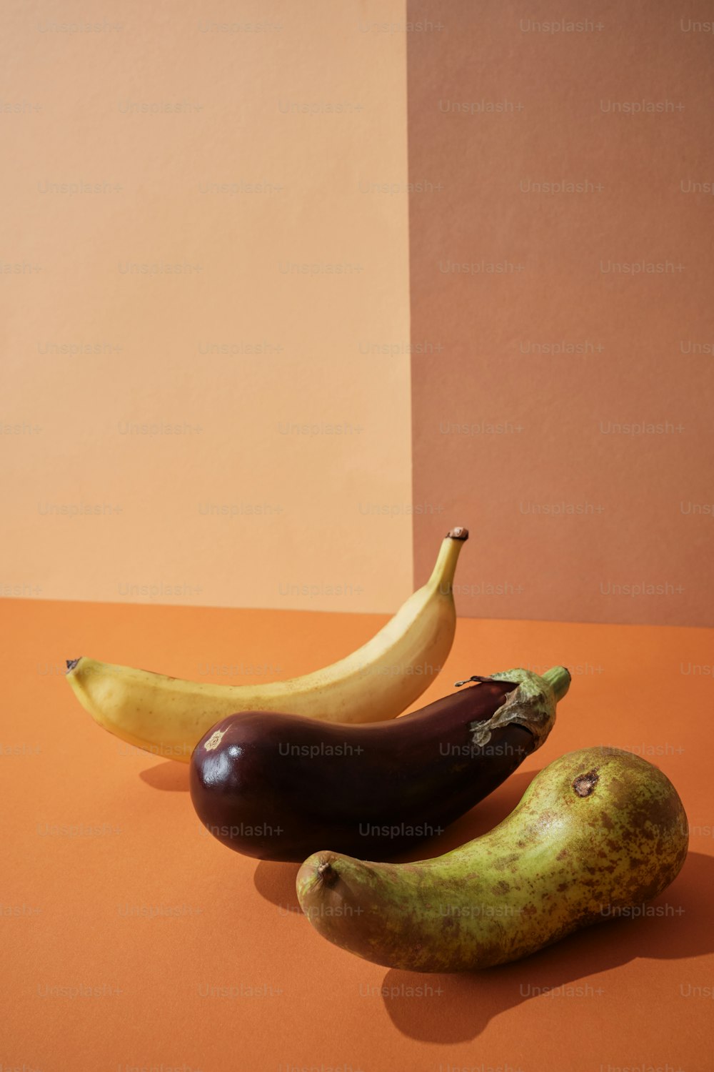 a couple of bananas and a eggplant on a table
