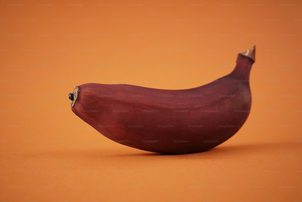 주황색 표면 위에 놓인 빨간 바나나