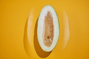 a half eaten kiwi sitting on top of a yellow surface