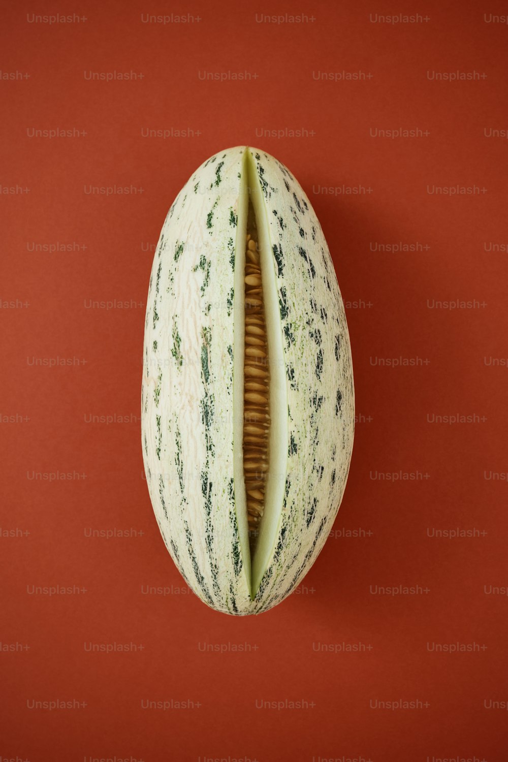 a melon sliced in half on a red background