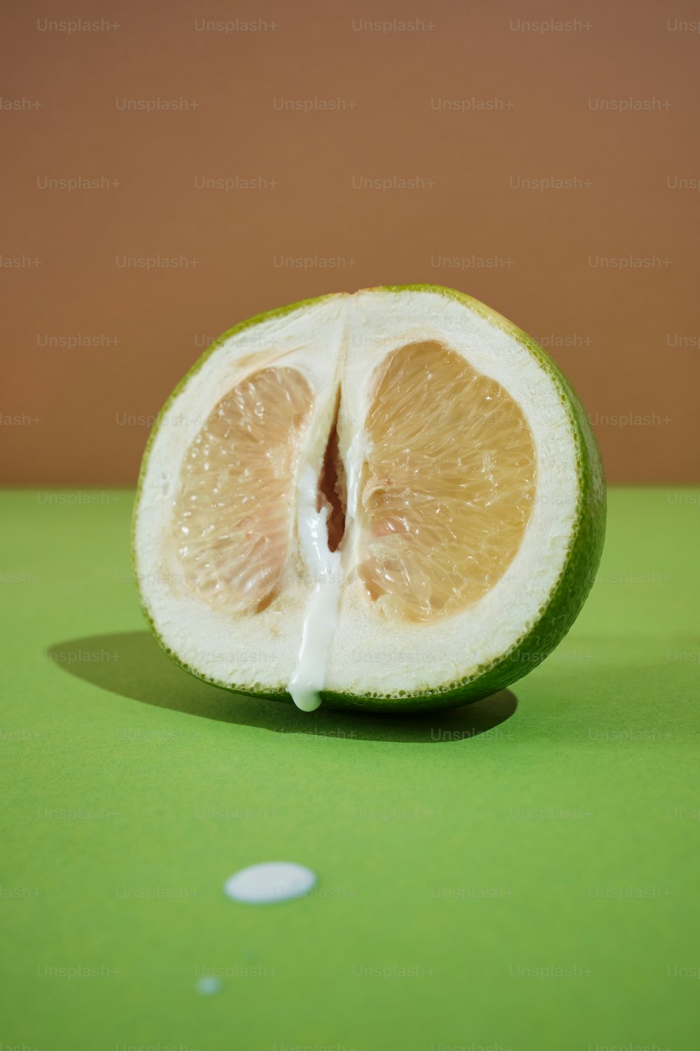 a half of a lime sitting on top of a green table