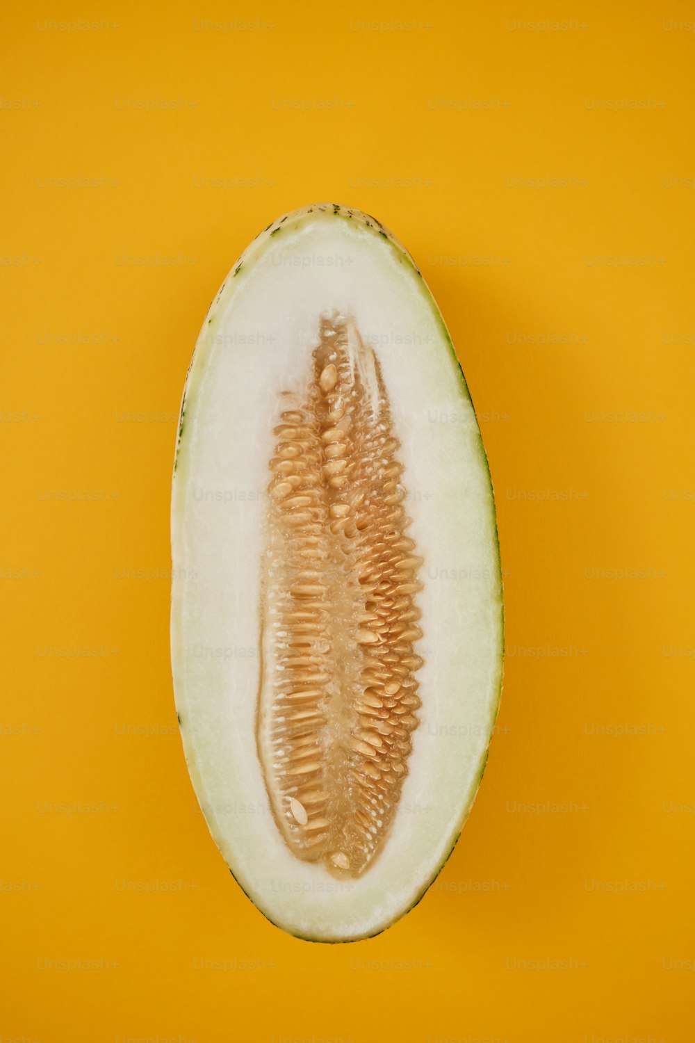 a half eaten melon on a yellow background