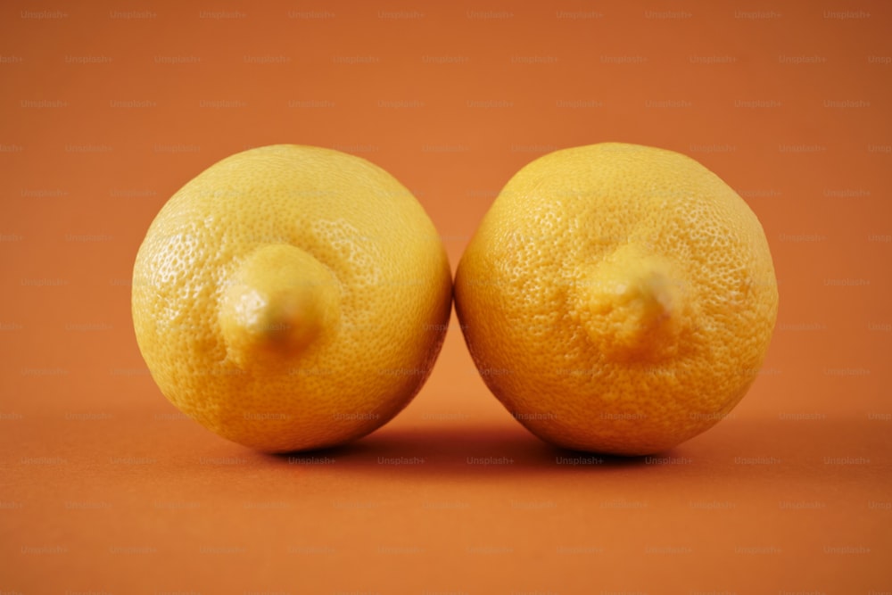 Dos limones sentados uno al lado del otro en una mesa