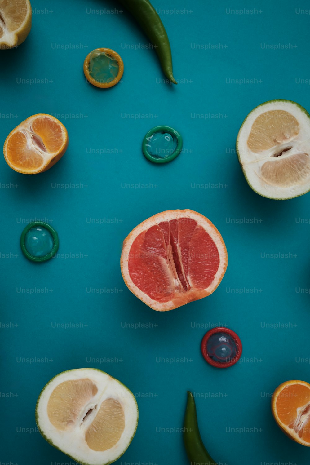 a grapefruit, lemon, pepper, and pepper on a blue surface