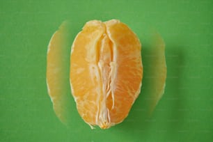 a peeled orange sitting on top of a green surface