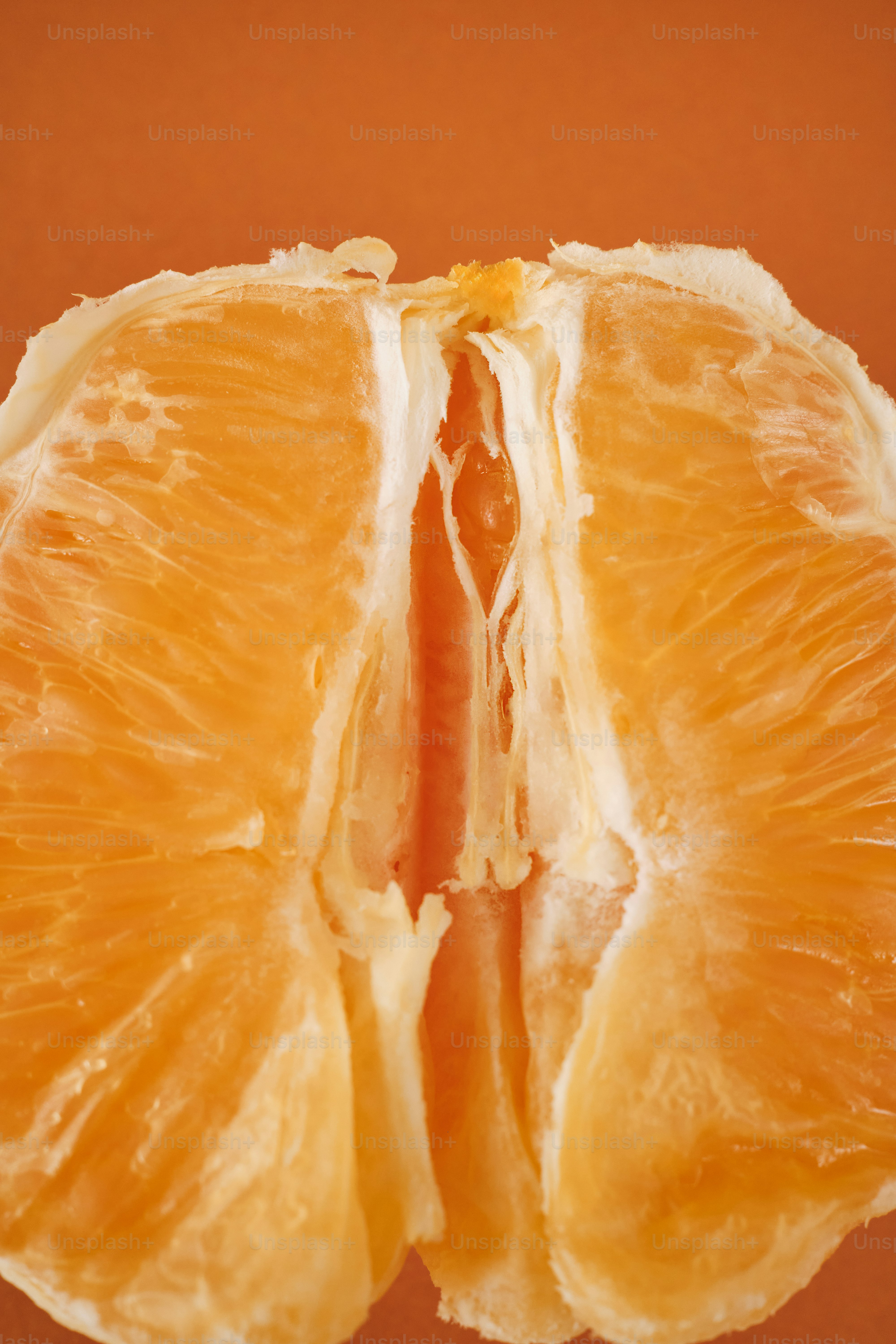 an orange cut in half on a brown background