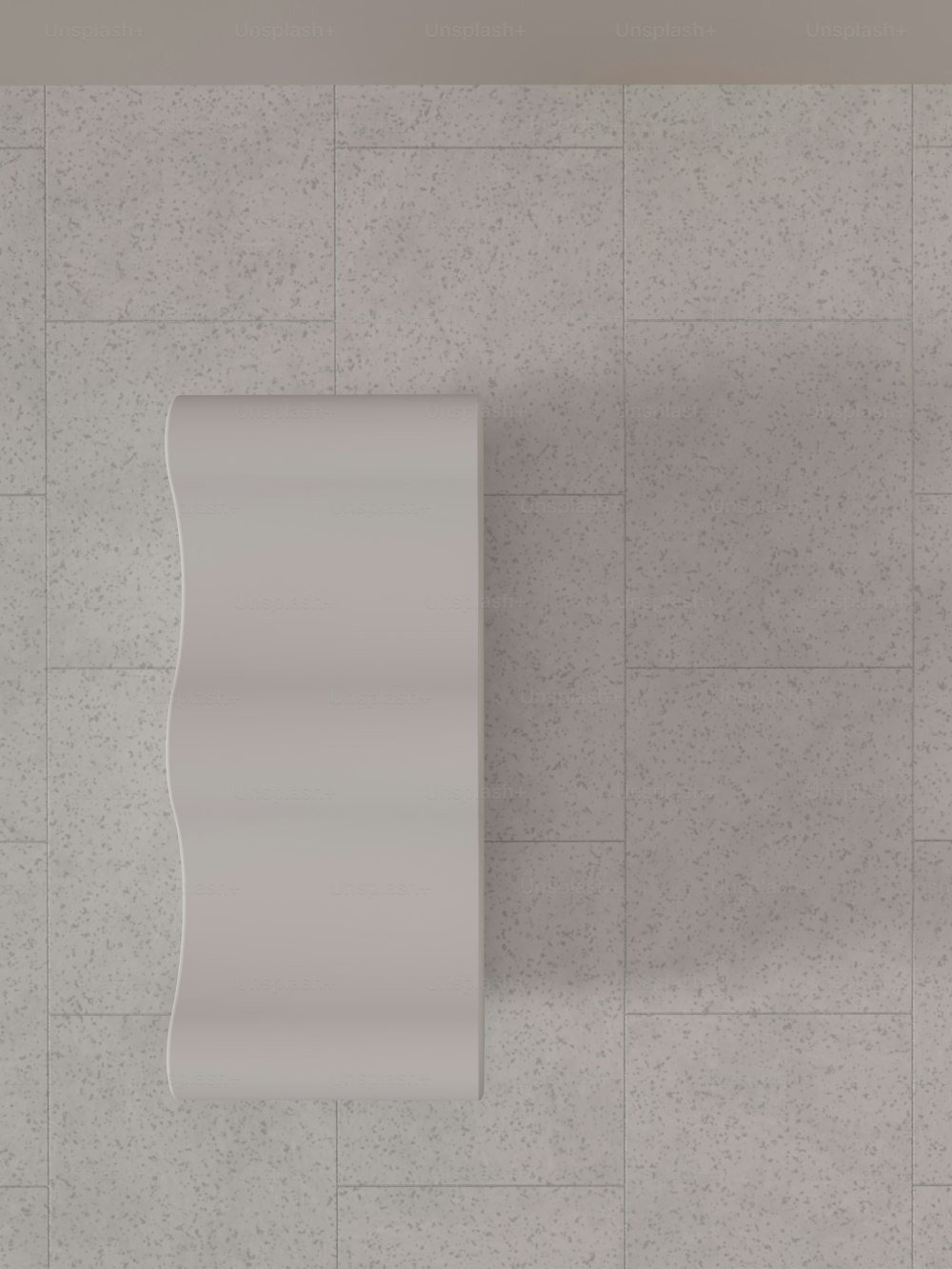 Eine Draufsicht auf ein weißes, an der Wand montiertes Urinal