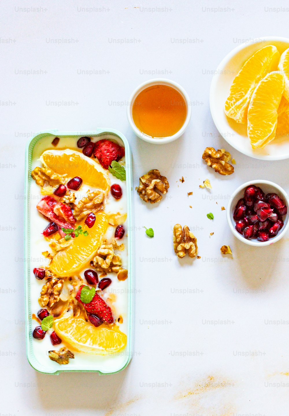 ein Tablett mit Obst und Nüssen neben einer Tasse Tee