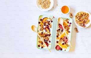 a couple of trays filled with fruit and granola