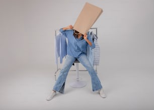 a woman sitting on a chair holding a cardboard box over her head