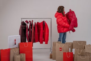 a woman standing in front of a rack of clothes