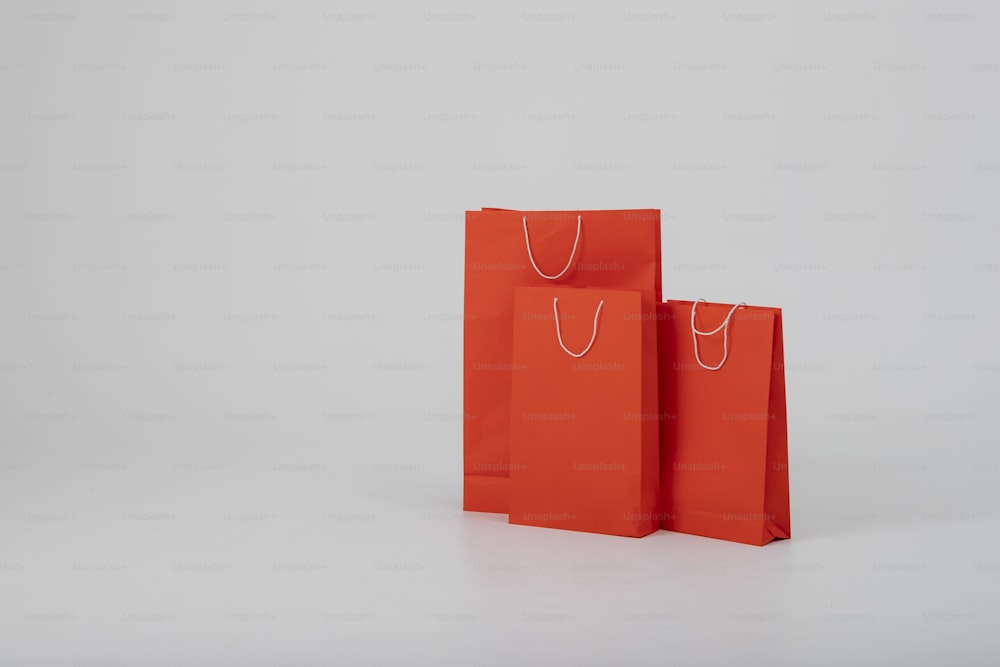 two red shopping bags sitting side by side