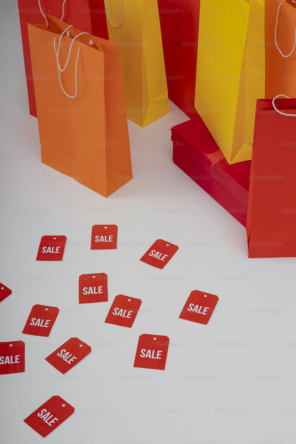 red and yellow shopping bags with sale tags on them