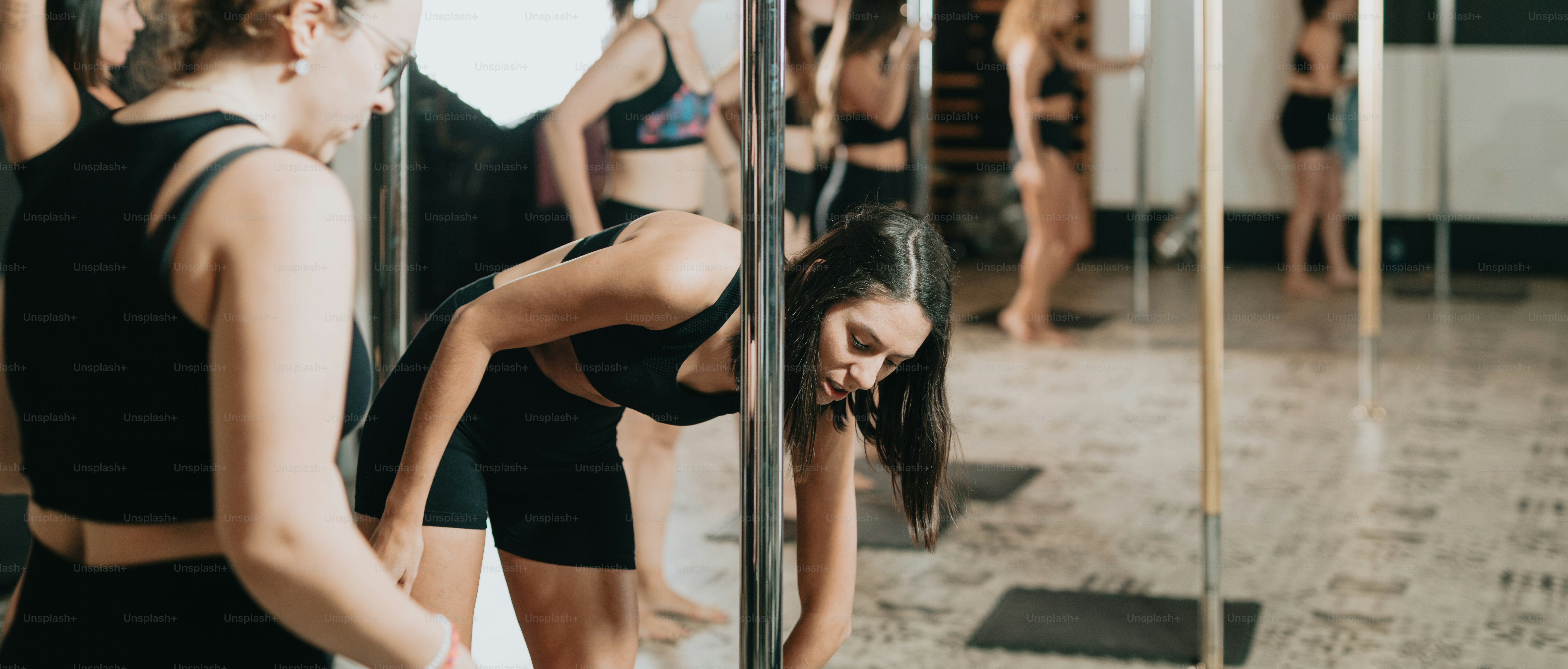 a woman in a black sports bra looking at her reflection in a mirror
