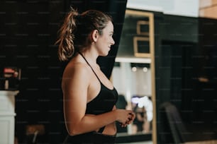 a woman in a black sports bra looking at her cell phone