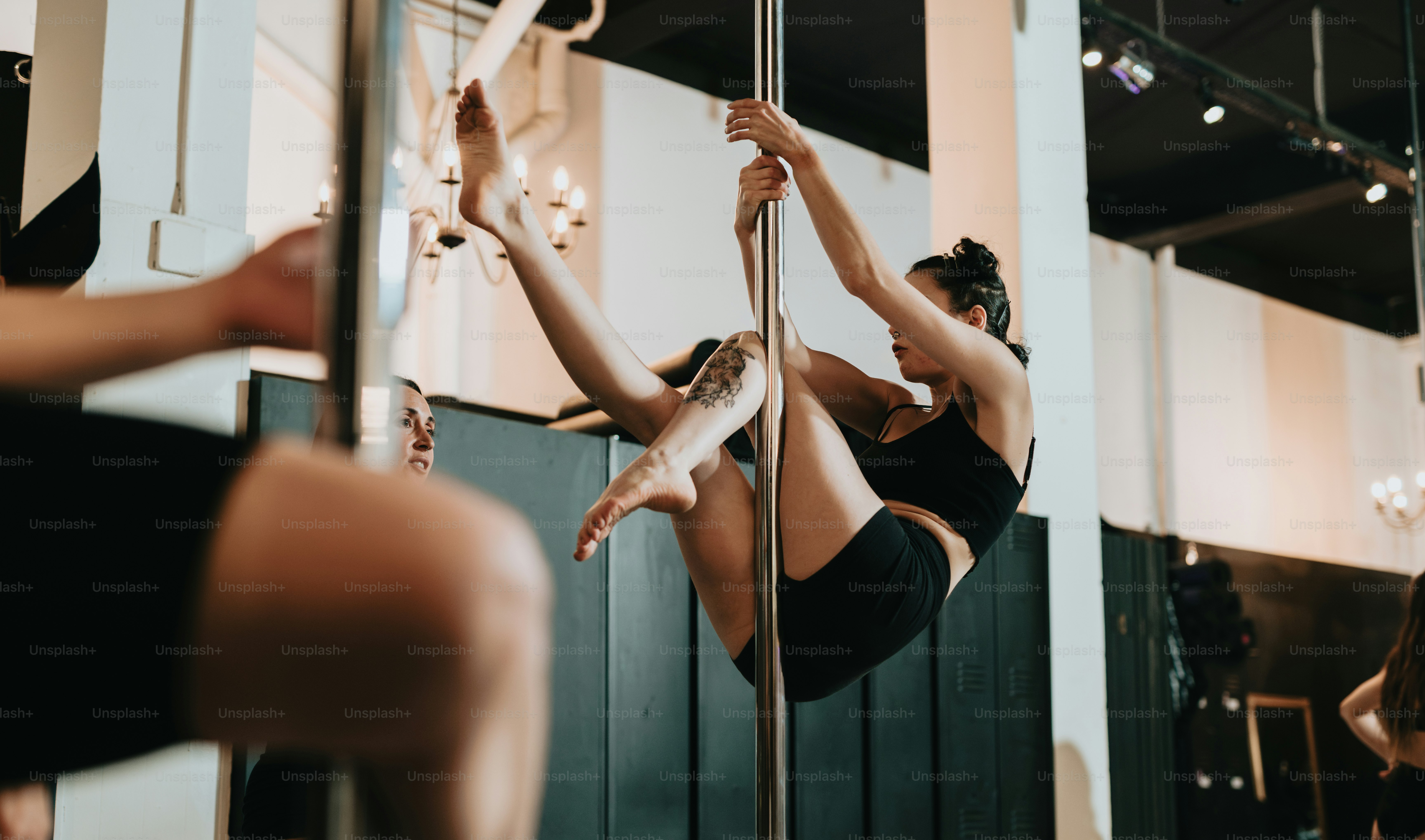 a woman hanging upside down on a pole