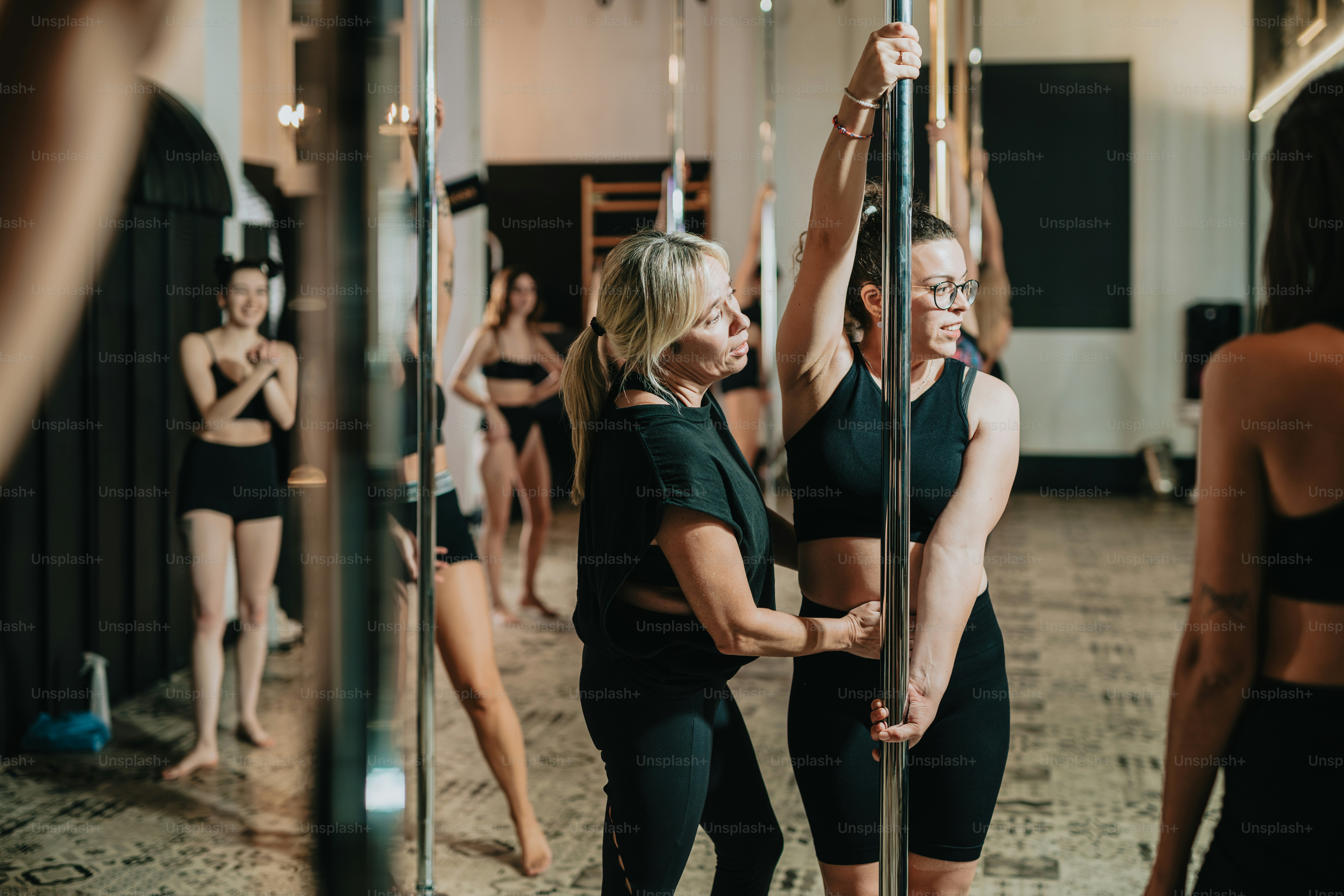 a group of women standing around each other in a gym