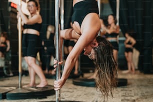 a woman is doing a handstand on a pole