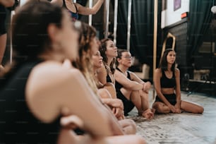 a group of women sitting on the floor in front of a mirror