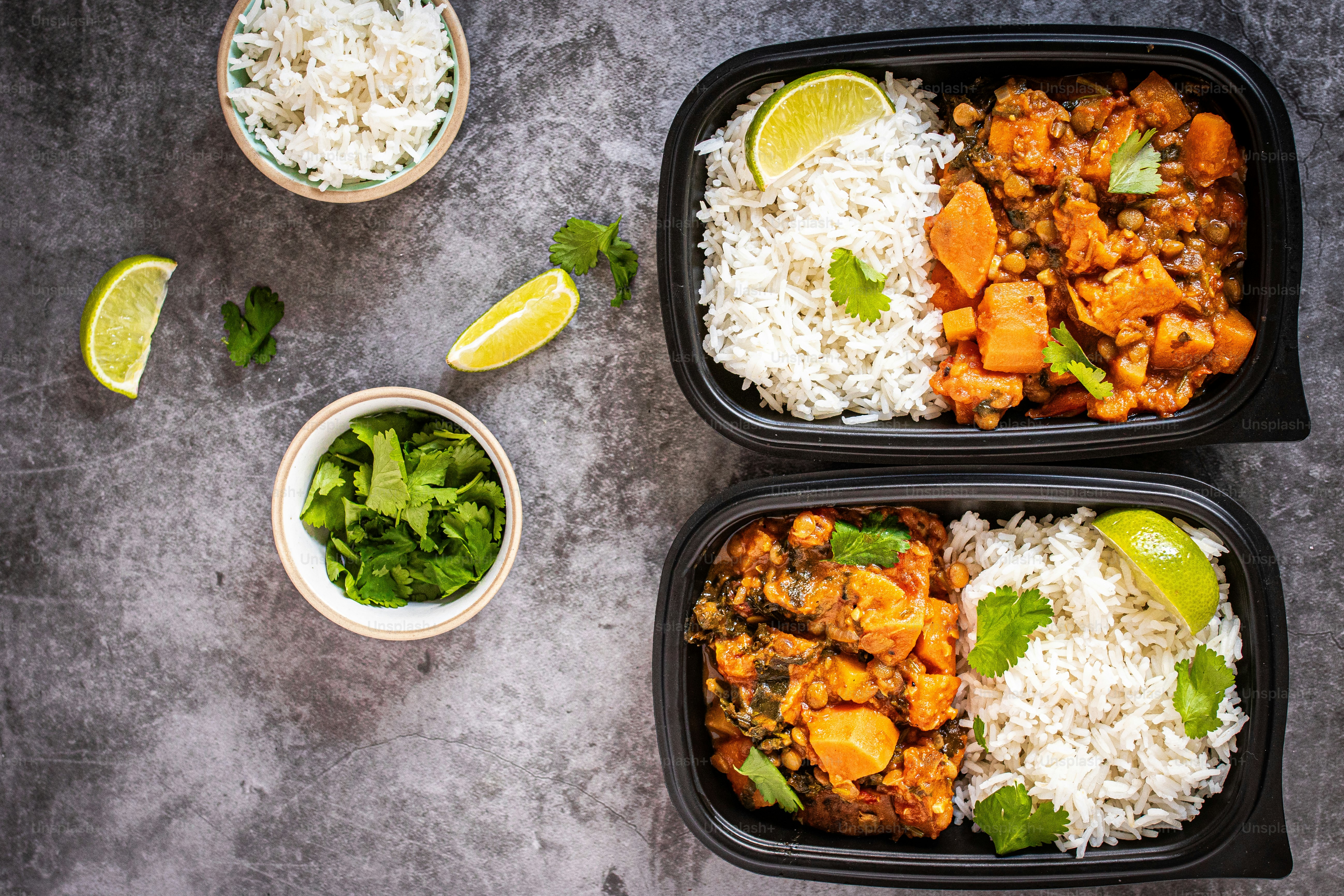 Two black containers filled with rice and vegetables photo – Meal ...
