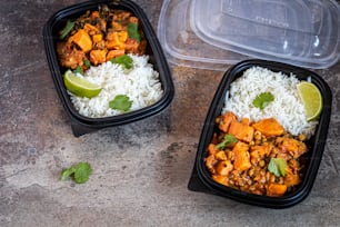 two plastic containers filled with rice and vegetables
