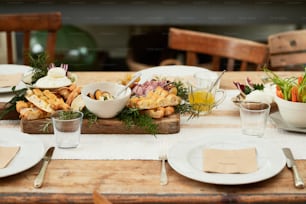 a wooden table topped with plates and bowls of food