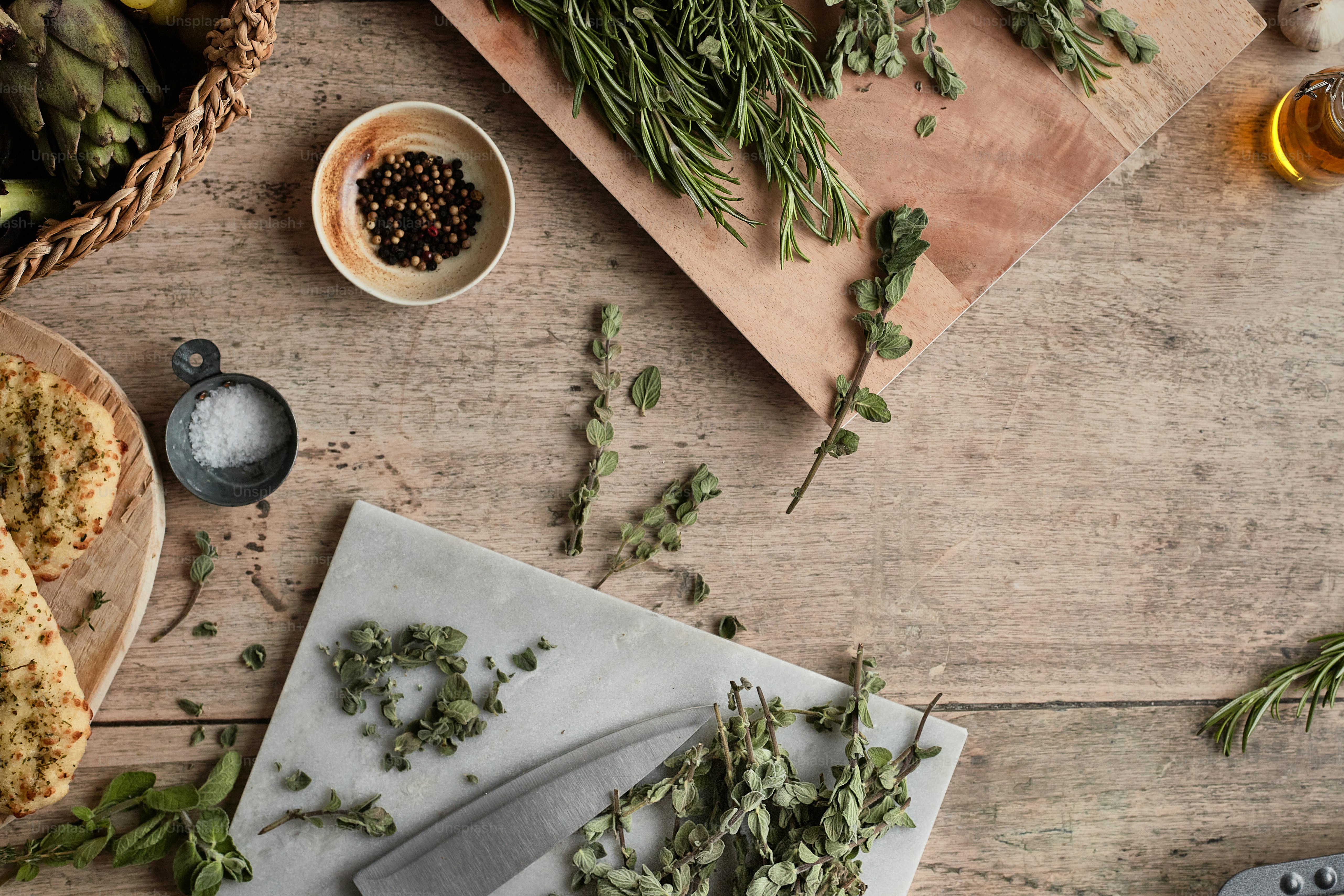 a cutting board topped with herbs next to a knife