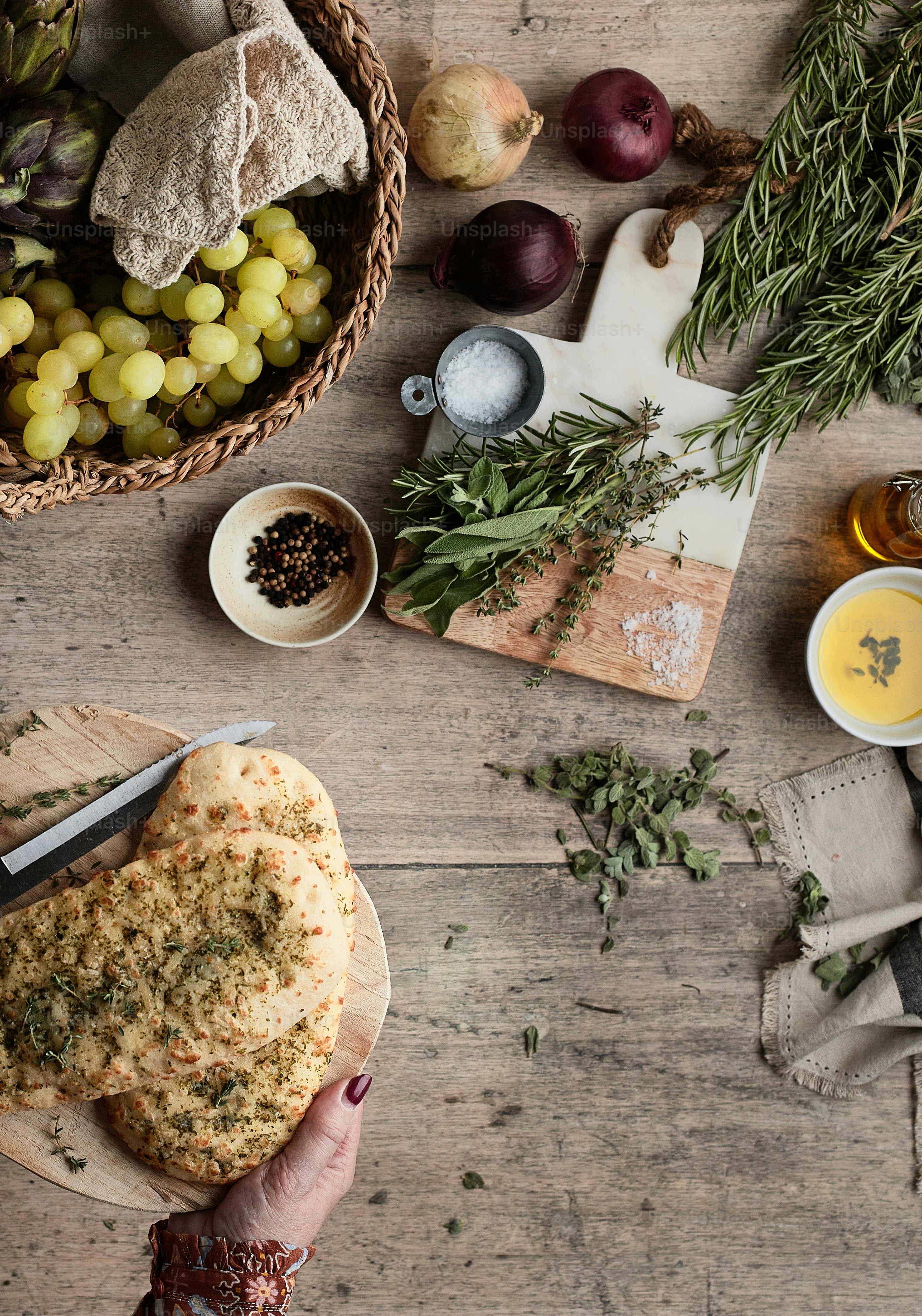 a person holding a pizza on a cutting board
