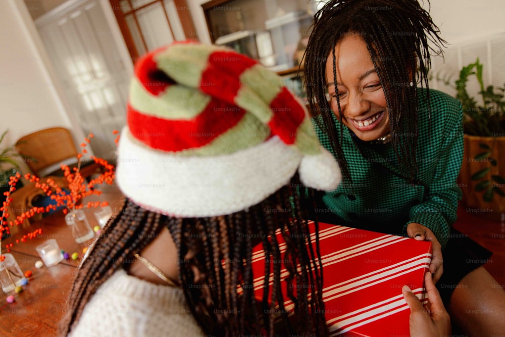 a woman with dreadlocks smiles as she holds a present