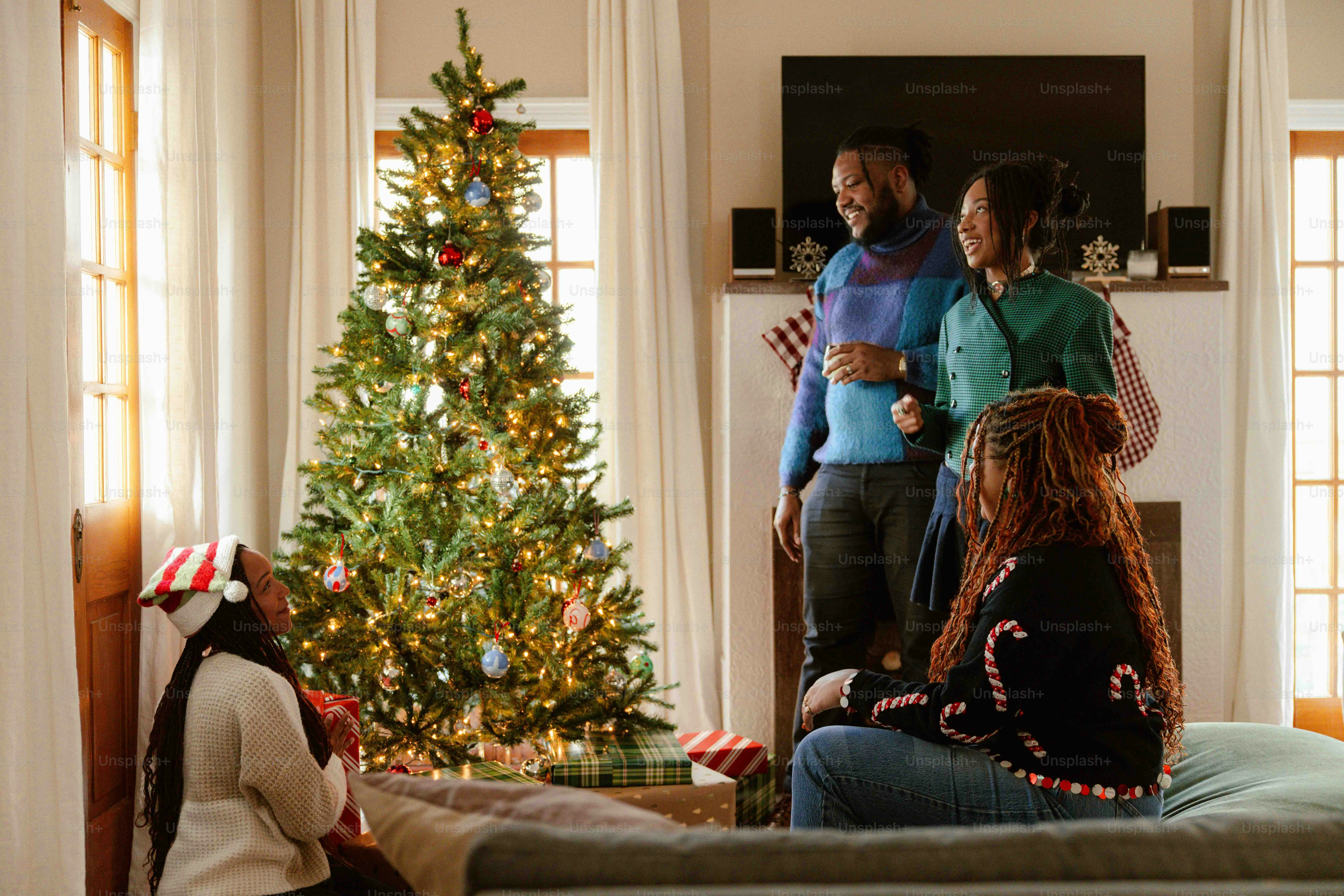 a group of people standing around a christmas tree
