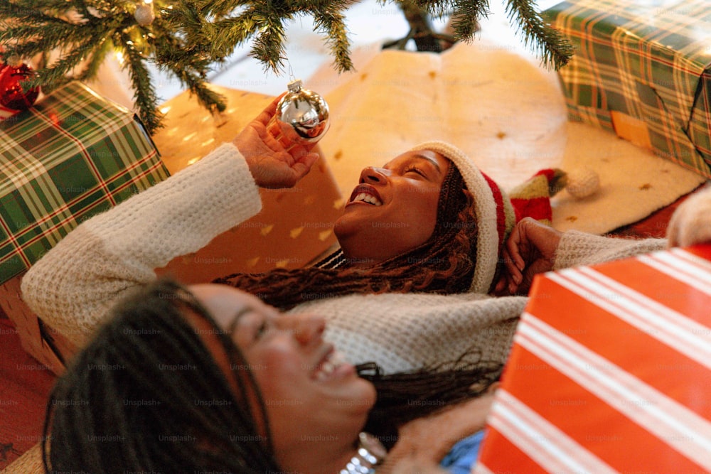 Una mujer acostada en el suelo sosteniendo un adorno navideño