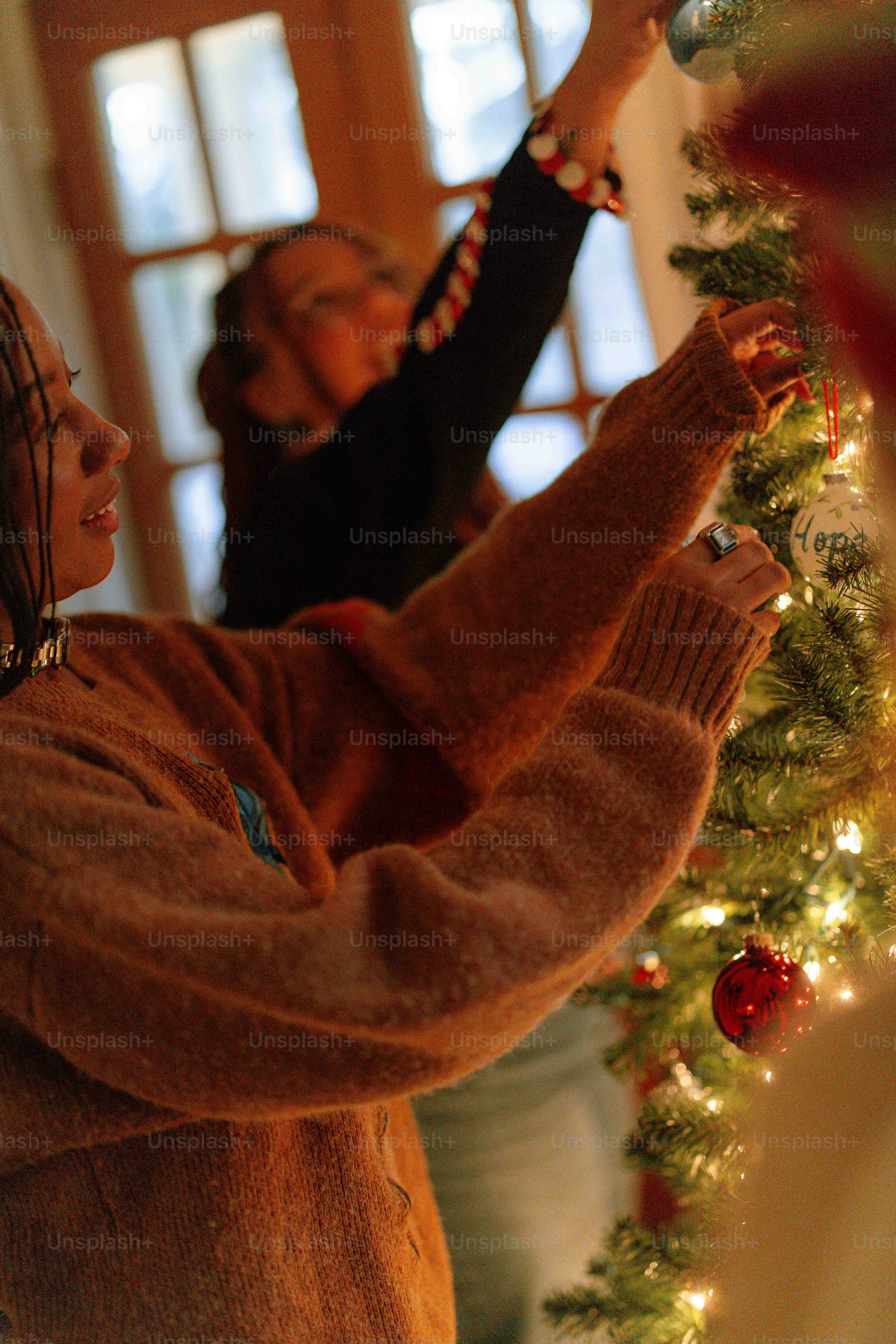 two women decorating a christmas tree together