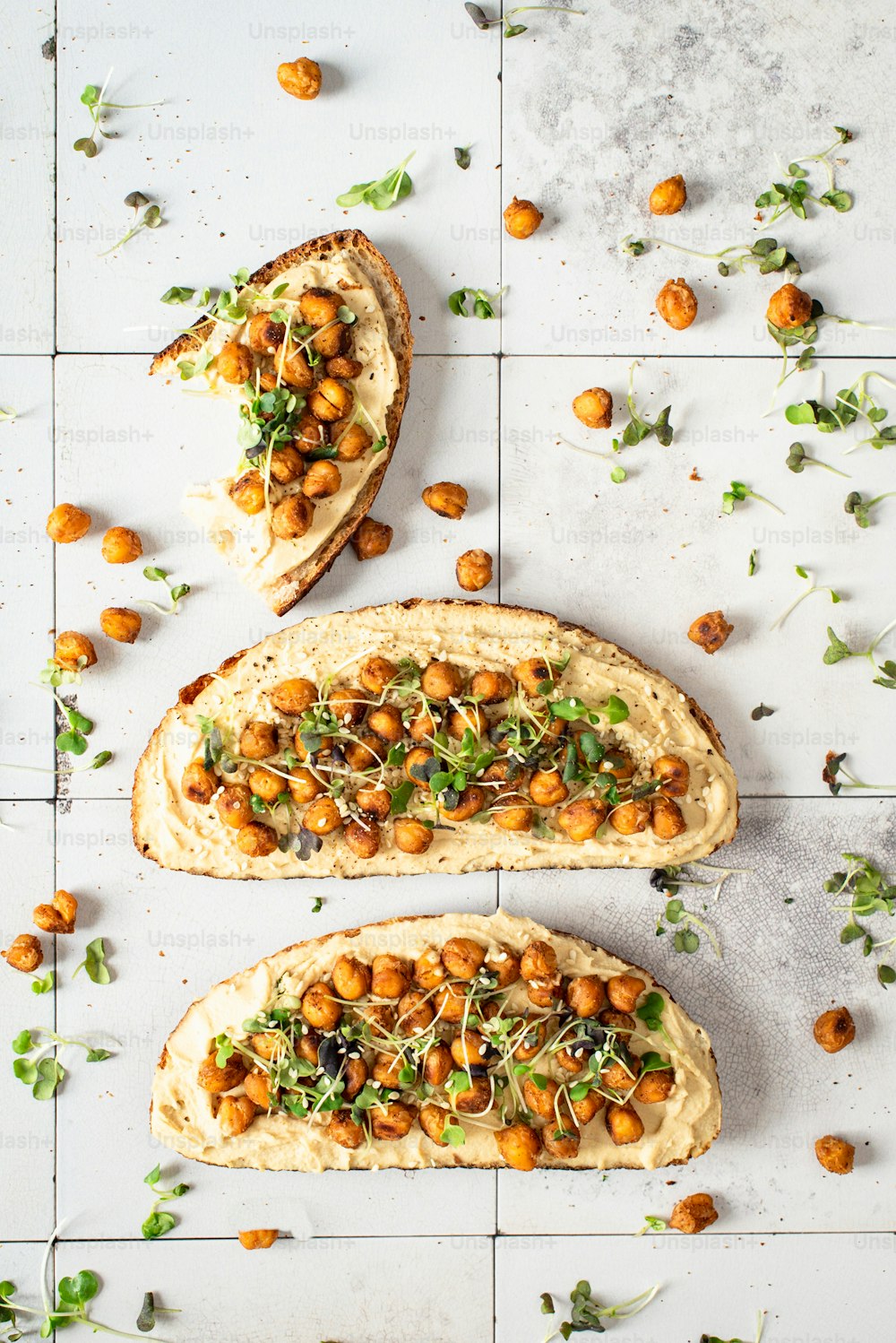 two pieces of bread topped with chickpeas and greens