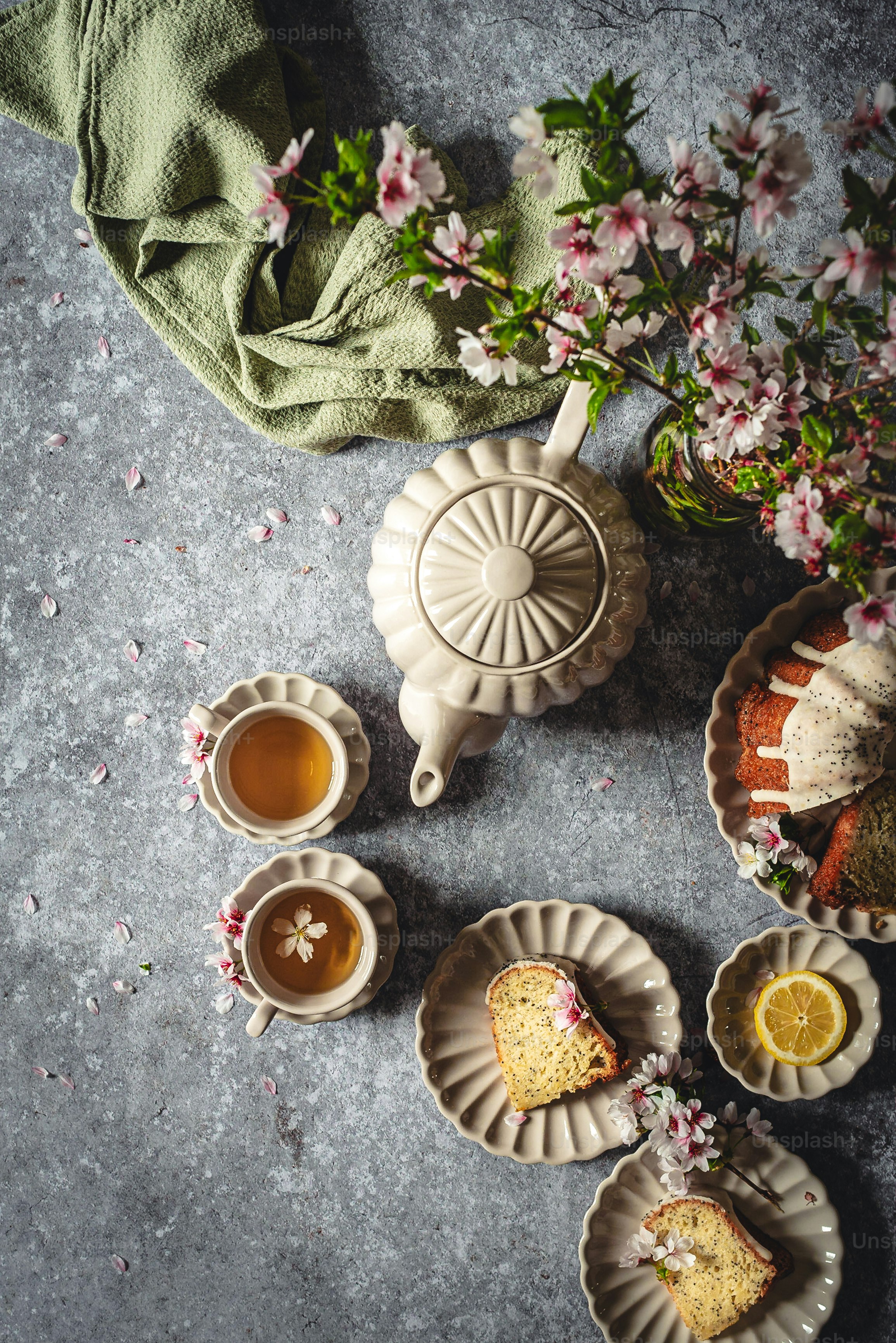 a table topped with plates of food and cups of tea