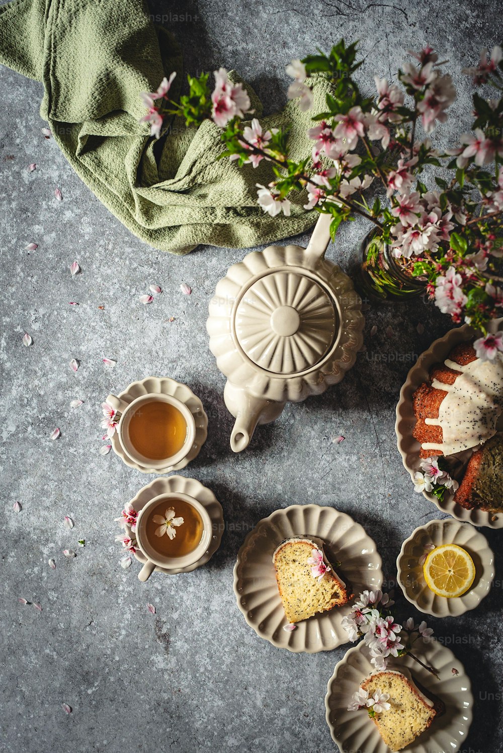 a table topped with plates of food and cups of tea