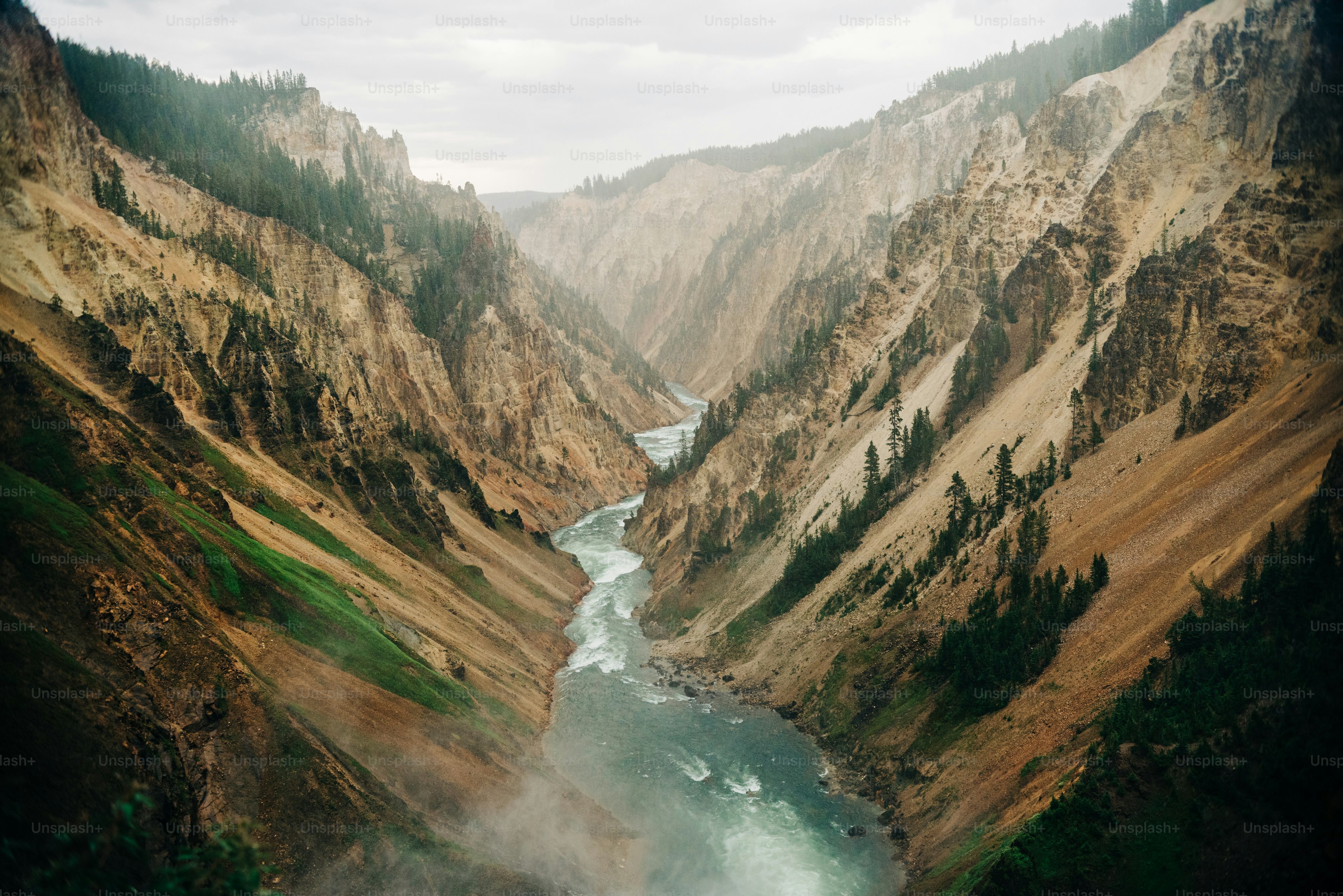 a river flowing through a canyon surrounded by mountains