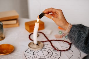 una persona encendiendo una vela encima de una mesa