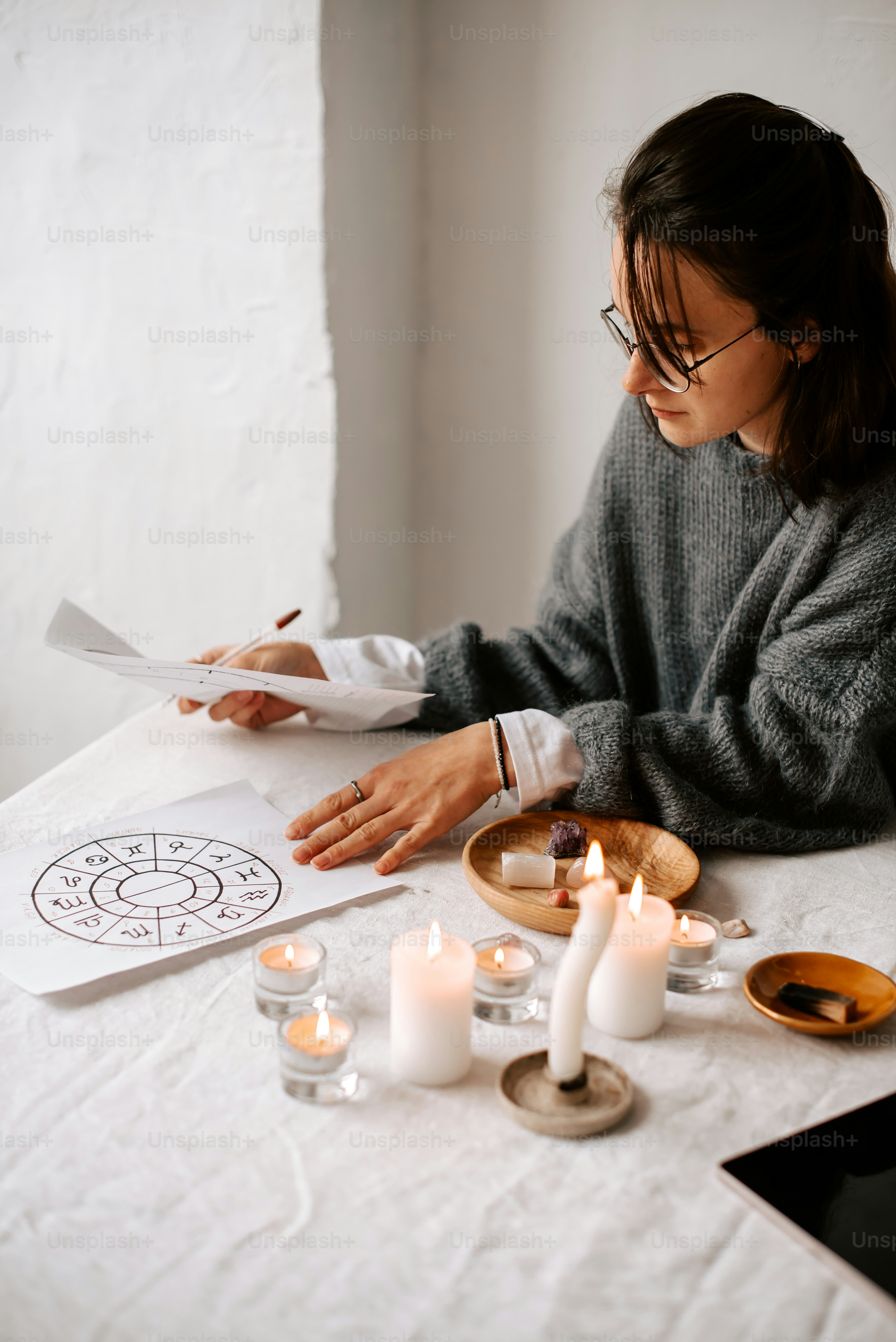 una mujer sentada a una mesa con unas velas