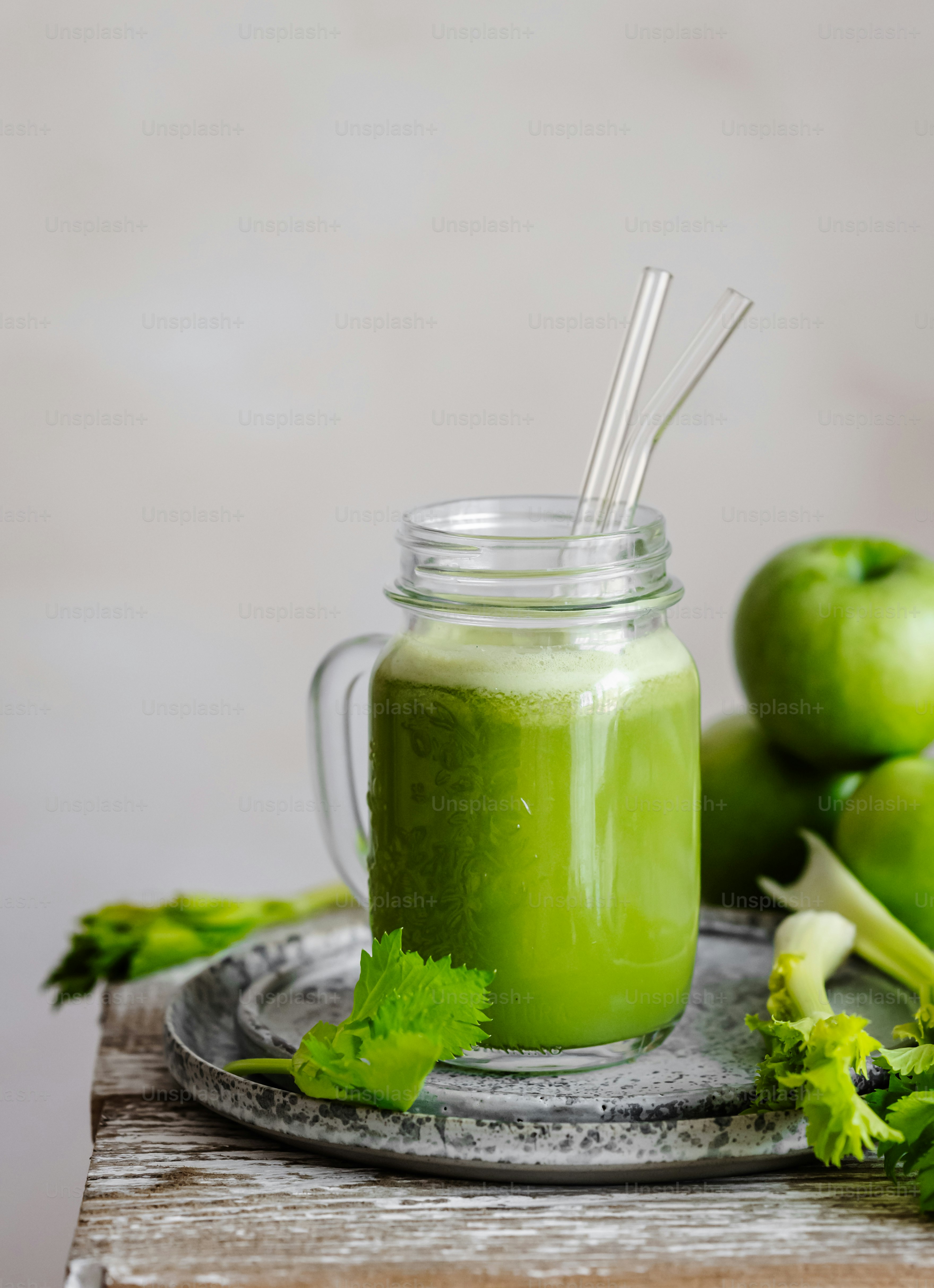 a green smoothie in a mason jar with a straw