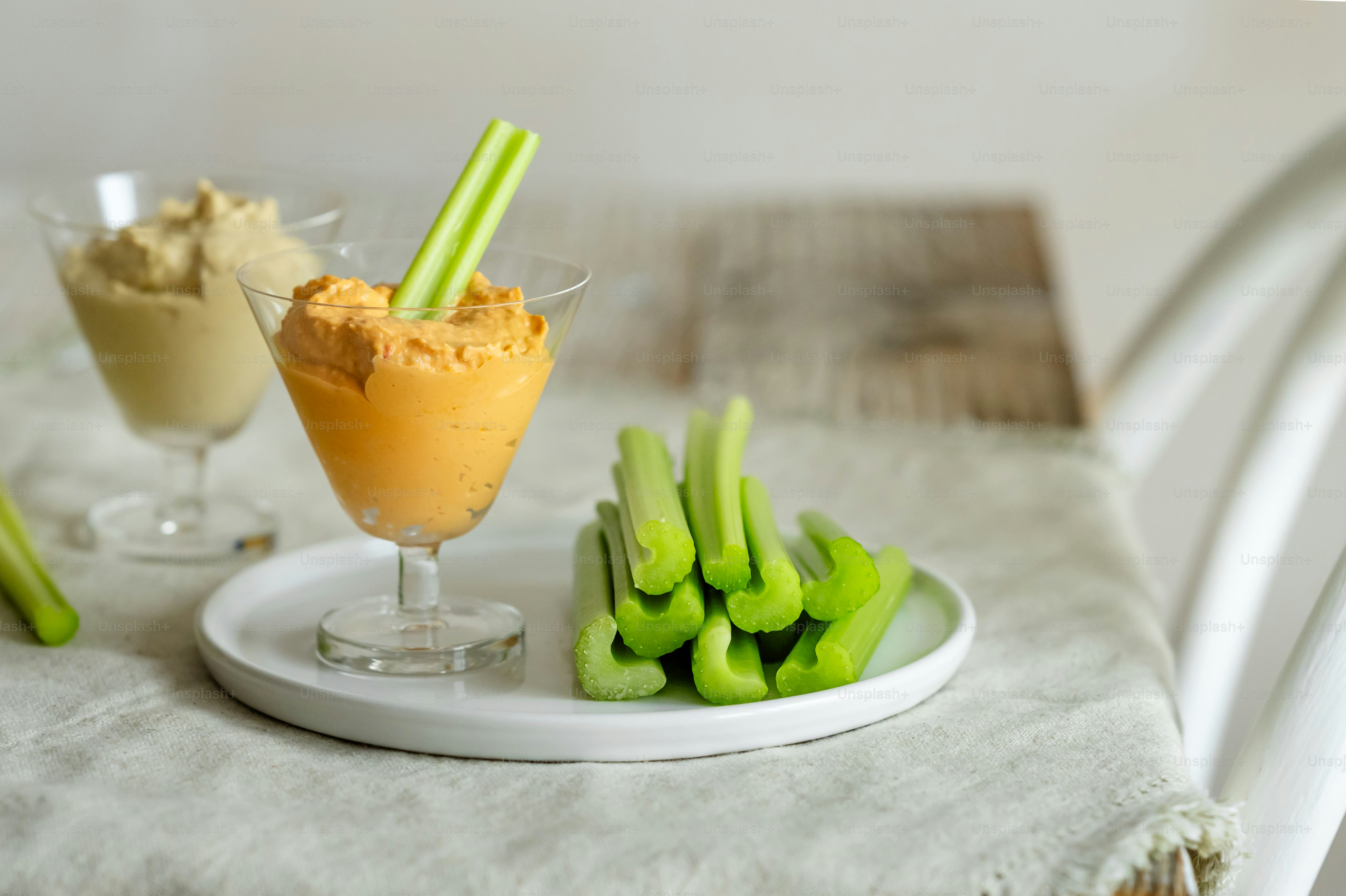 a plate of celery sticks next to a glass of ice cream