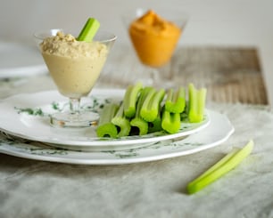 a plate with celery sticks and a bowl of dip