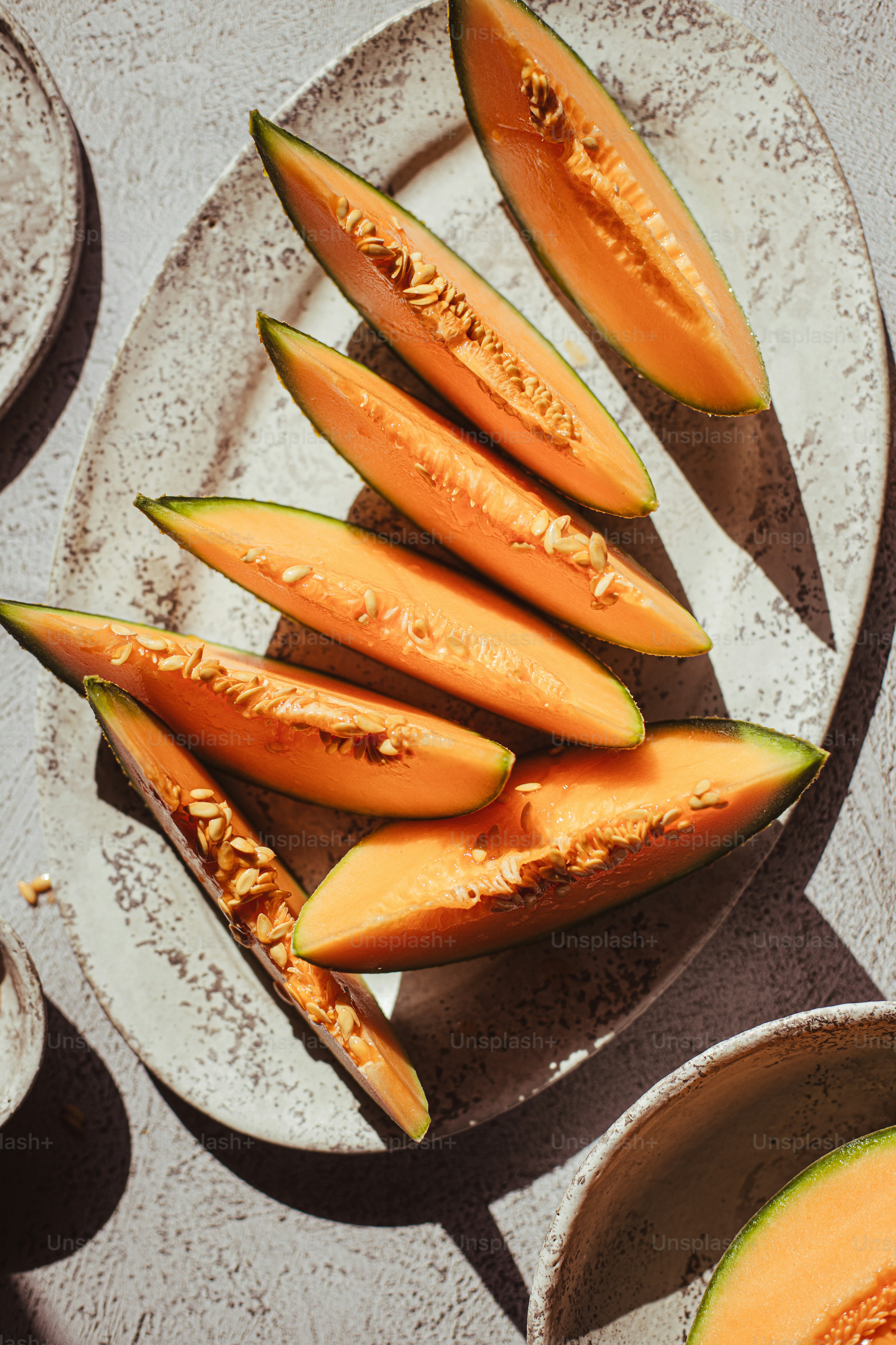 メロンのスライスをトッピングした白い皿