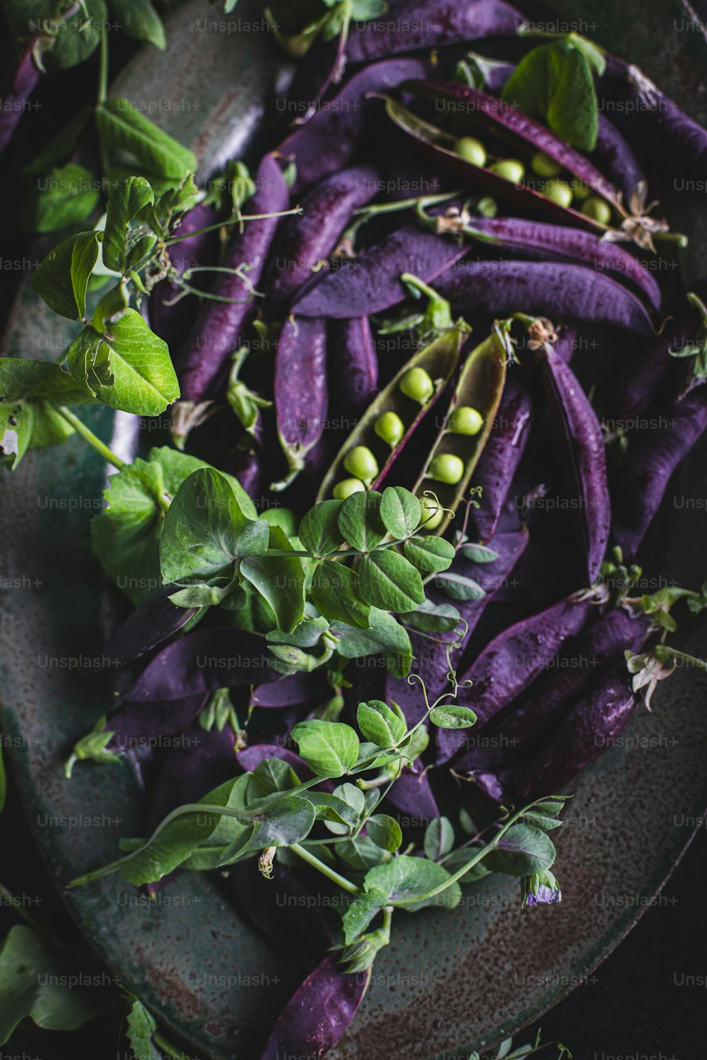 a plate of purple vegetables with green leaves
