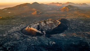 an aerial view of a mountain range at sunset