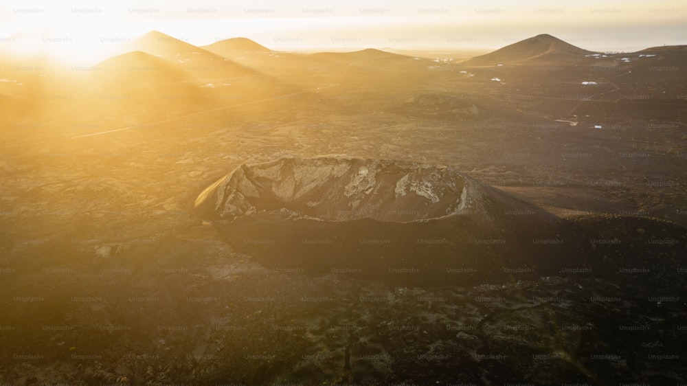 an aerial view of a mountain range at sunset