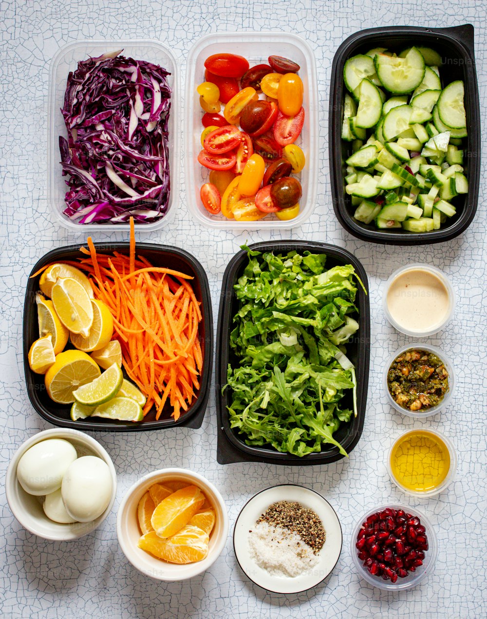 a table topped with plastic containers filled with food