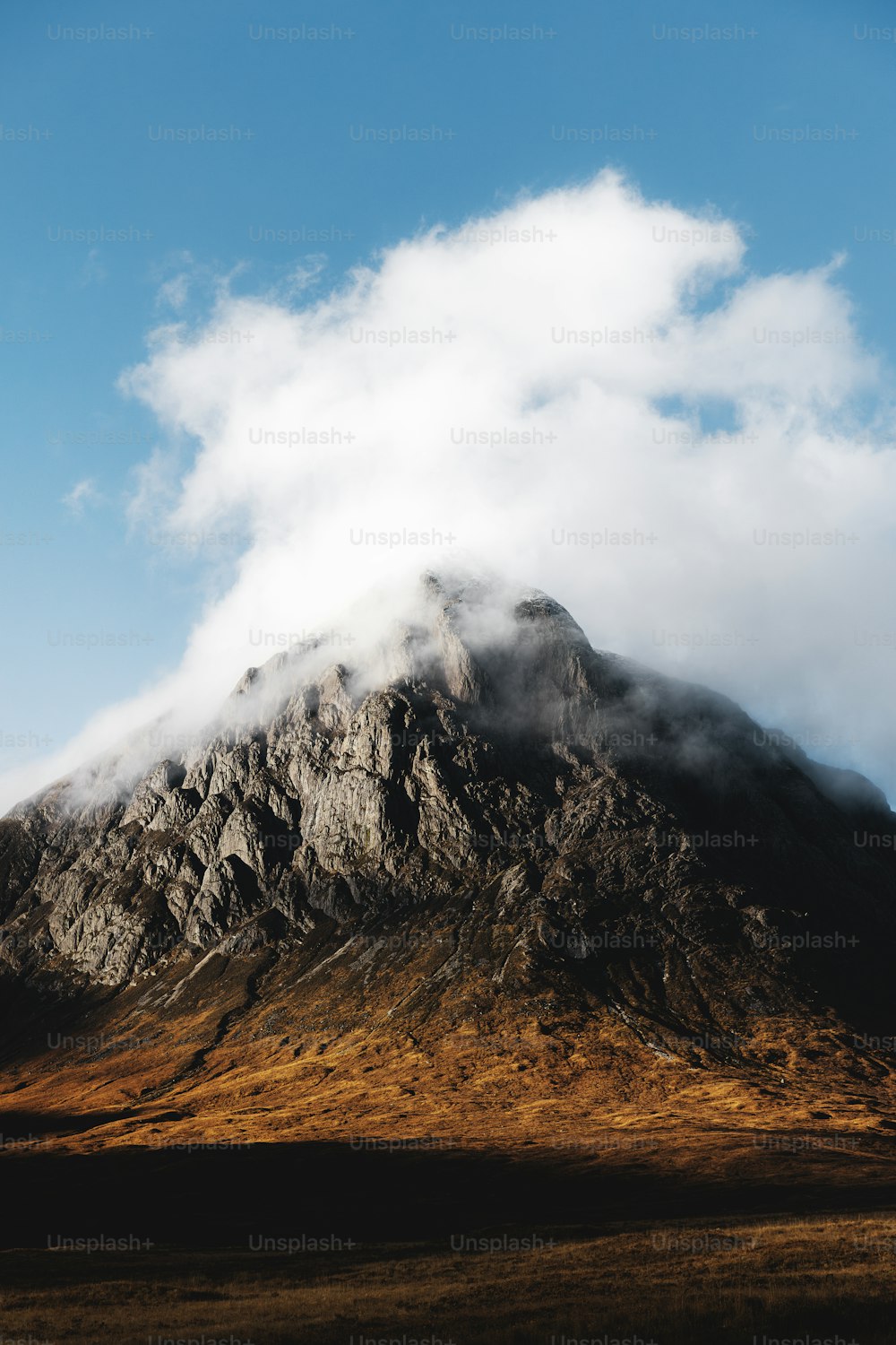 a very tall mountain with some clouds in the sky